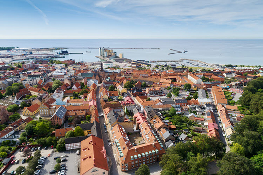 Vy över stad och hav i Ystad, där äldre bebyggelse möter nyare..