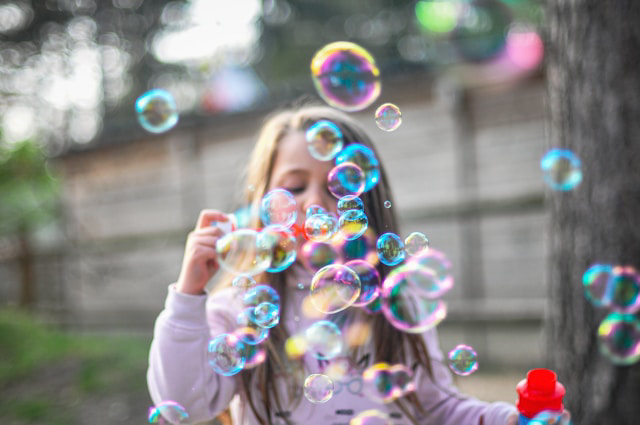 Foto på barn som blåser färgglada såpbubblor.