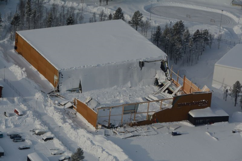 Tarfalahallen med snötäckt tak, halva byggandens tak  är inrasat och bråte syns i snön.