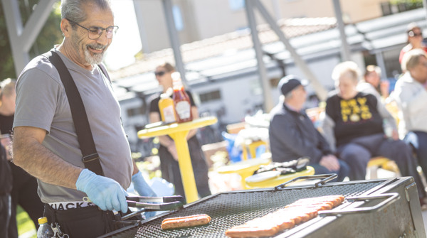 Gavlegårdarnas medarbetare grillar korv i bostadsområde.