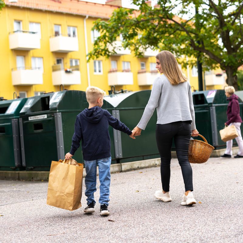 Bild på mamma och pojke vid en återvinningstation