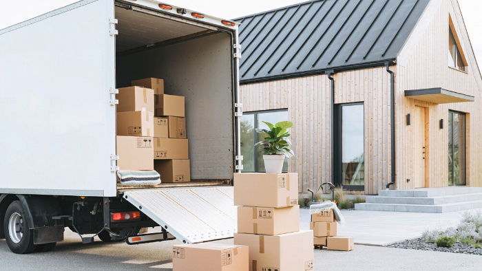 flyttbil och flyttkartonger framför villa