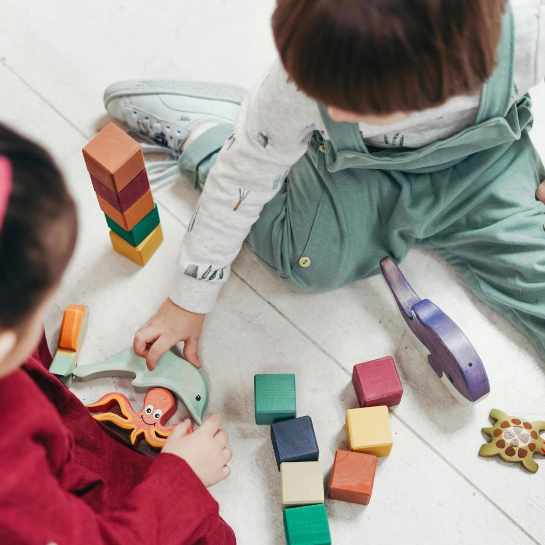 Små barn som leker med klossar på golvet